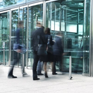 Businesspeople walking into glass building