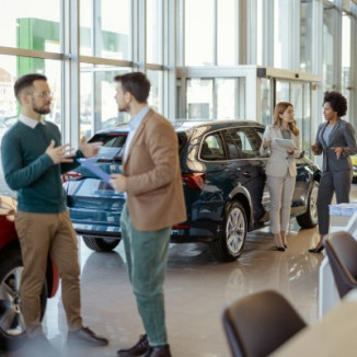 Two groups of people talking in busy dealership